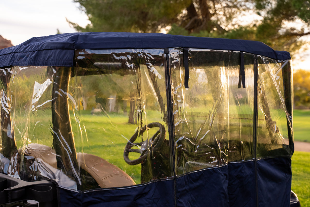 Navy Clear Vision cover side panel with clear windows and roll-up straps at golden hour