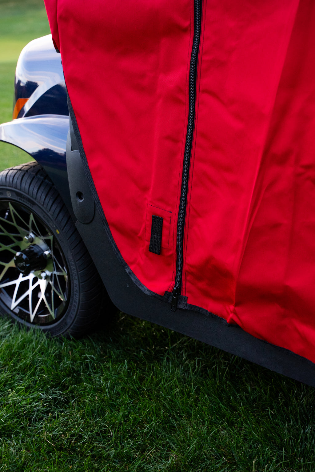 Red Clear Vision cover zipper and strap detail at the lower side panel